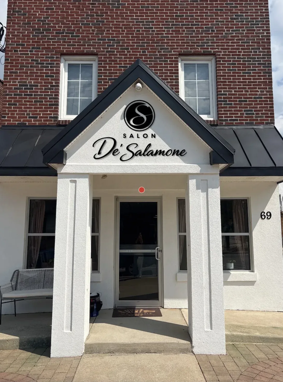Salon De' Salamone storefront with white columns on a brick building